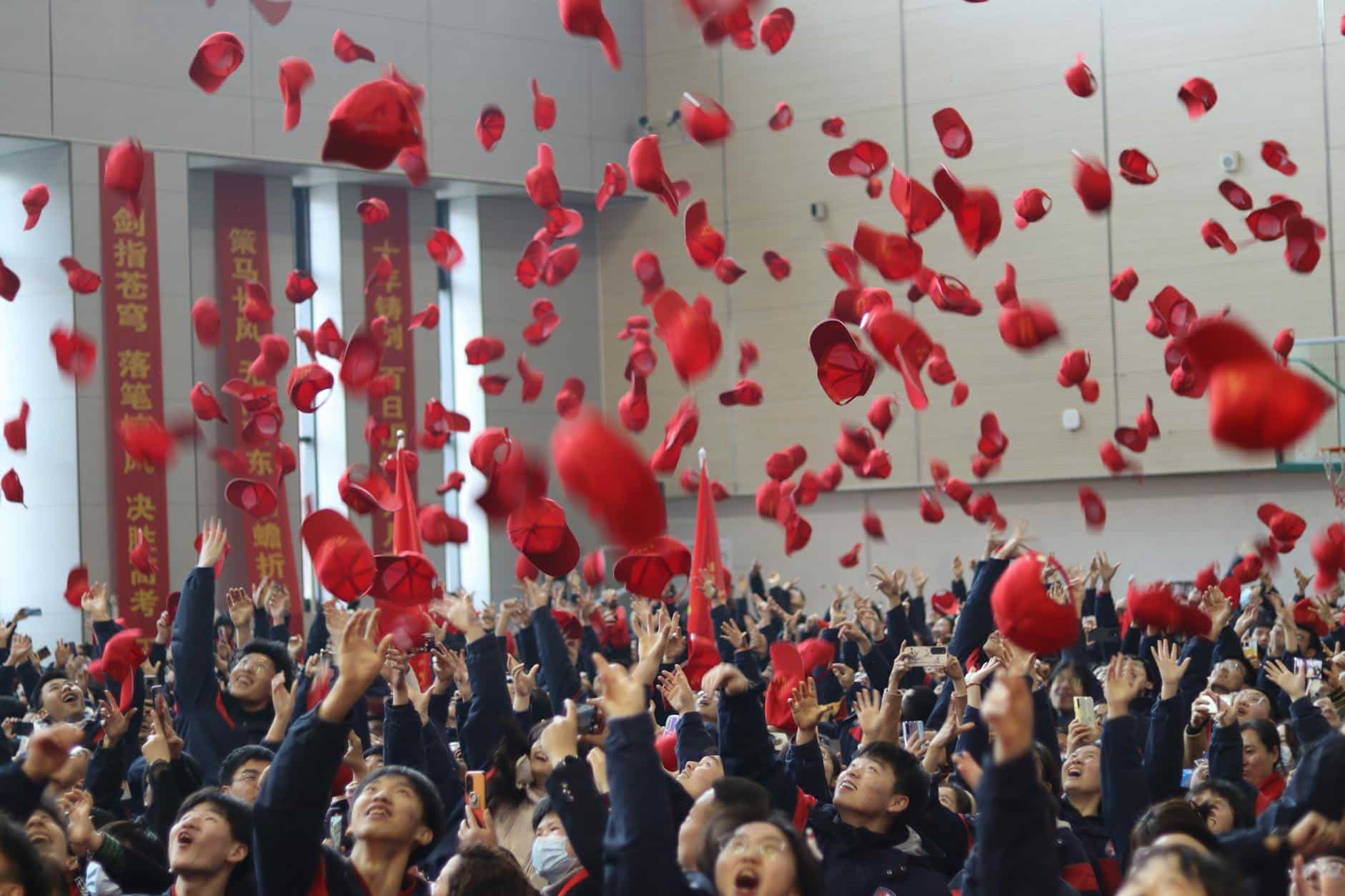 crowd throwing red caps in air